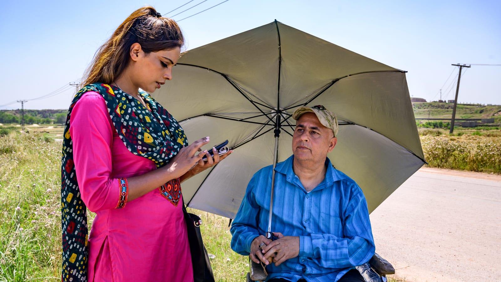 Photo 3 Photo of a man in a wheelchair answering the survey questions of a female healthcare worker.