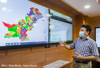 Information management Technical officer for information management shows data on Pakistan's COVID-19 response in an operations room.