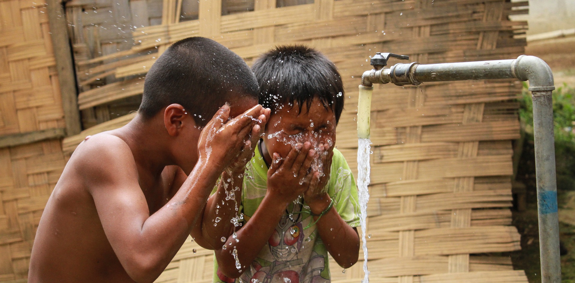 WASH-in-Lao-PDR-cropped 2 children wash at a water tap