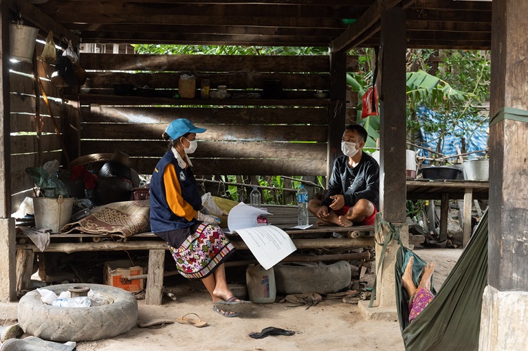 Malaria A health worker sits with a local farmer