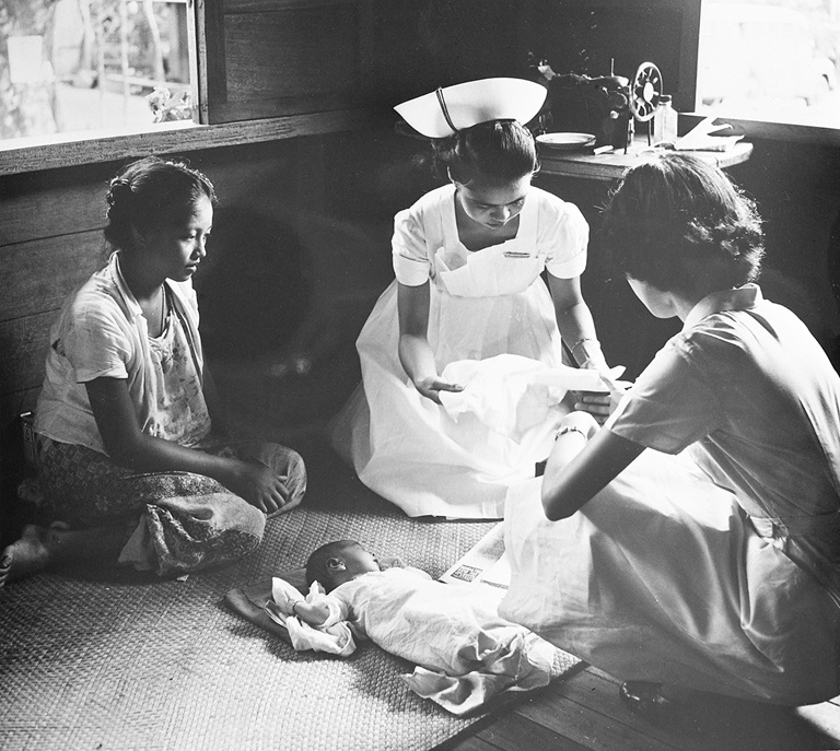 1951 Student-nurse Paz Basconcillo (middle) shows Maxima Madreniko (left), a 17-year-old mother from Quezon City, how to care for her week-old son. Basconcillo is being trained by public health nurse Zenaida Panlilio (right) who helped her deliver the baby at Madreniko’s home.